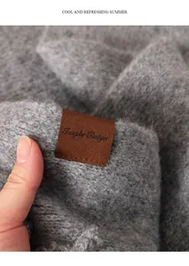 Primer plano de la etiqueta de marca en una bufanda de punto gris para mujer en invierno.