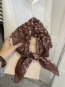 Detailed macro shot of brown cotton linen square scarf with white paisley patterns