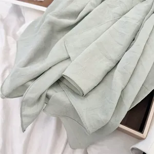 Macro view of light green breathable pleated square scarf showing soft fabric texture