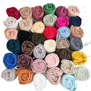 Wide assortment of solid color crinkled cotton blend scarves and turbans for women