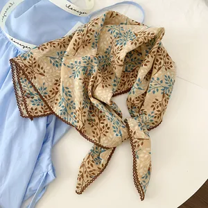 Macro view of cotton floral square scarf featuring blue leaf patterns and delicate lace edges