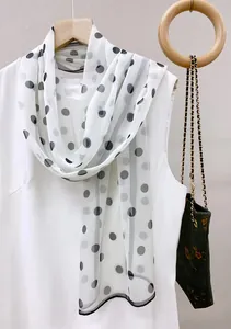 Elegant white chiffon long scarf with black polka dots detail on a wooden hanger display