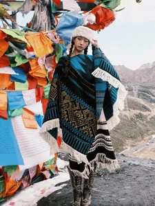 Warmer Strickponcho im Ethno-Stil mit blauen Mustern und Fransen für kalte Tage