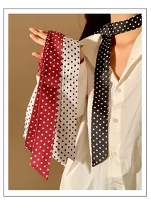 Gedetailleerde weergave van drie retro polkadotsjaals in de kleuren rood, wit en zwart.