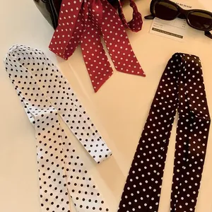 Vintage stippen lint sjaals in wit, rood en zwart op een minimalistische achtergrond