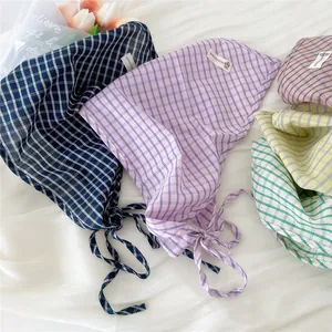 Una collezione di foulard triangolari in cotone a quadri colorati in varie tonalità pastello