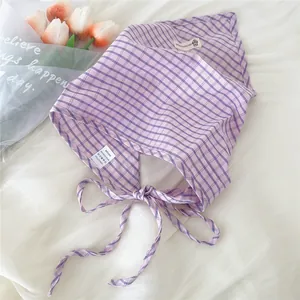 Vista dettagliata di una bandana a scacchi viola con lacci regolabili e tessuto morbido