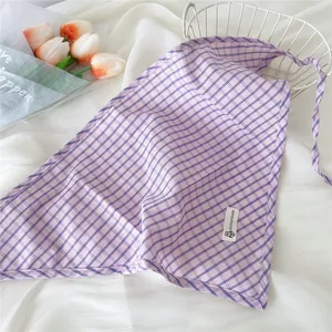 Dettaglio ravvicinato di una bandana a triangolo a quadretti viola con etichetta chic