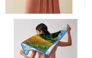 Back view of a woman holding a large silk square scarf featuring a Van Gogh oil painting.