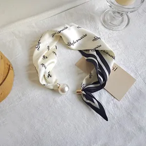 Elegant cream silk neck scarf for women featuring a faux pearl and black cursive print