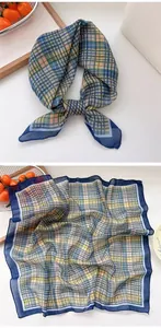 Close-up detail of vintage plaid square neck scarf with soft texture and blue border.