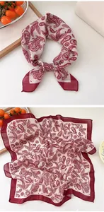 Detailed view of square scarf with red paisley pattern and vintage design