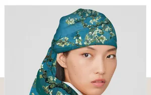Close-up detail of a Van Gogh Almond Blossoms art print silk scarf styled on a model.