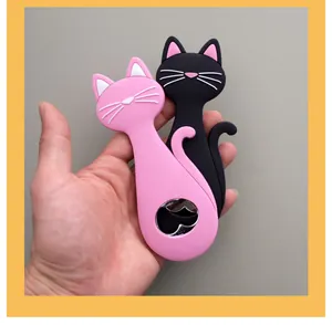 Handheld view of two creative cat-shaped silicone beer bottle openers in pink and black.