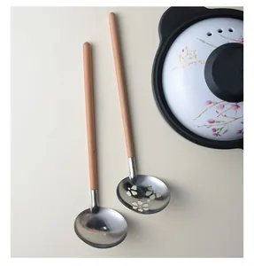 Close-up of 304 stainless steel soup and slotted spoons featuring long solid wood handles