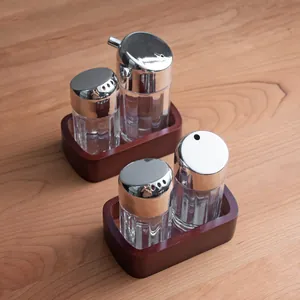 Nordic style acrylic condiment shaker set with elegant dark wood storage bases for kitchen
