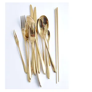 Close-up of a mirrored gold stainless steel cutlery set including spoons, forks, and knives.