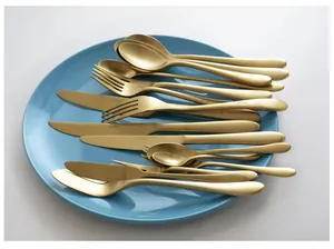 Détail d'un ensemble de couverts en or mat élégants sur une assiette bleue élégante.