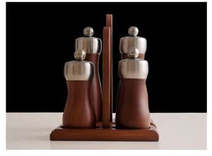 Elegant manual wood and stainless steel pepper mill set of four on a matching stand.
