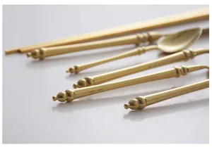 Detail showing the bamboo-joint design and polished golden finish of stainless steel cutlery