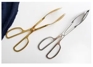 Detailed view of gold and silver stainless steel scissor-style food tongs on white background