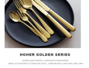Detail view of luxurious golden stainless steel cutlery set on a black plate.