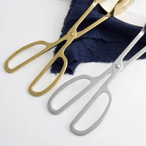 Gold and silver scissor-style stainless steel food tongs for BBQ and steak serving.