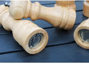 Close-up detail of the bottom grinding mechanism of a wooden manual pepper mill.