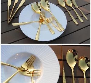Close-up of hammered gold cutlery set on a white plate and wood table