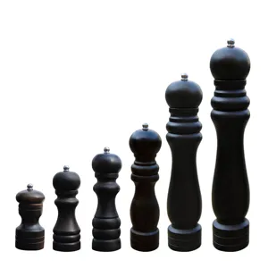 Set of six black wooden manual pepper grinders in varying sizes on white background