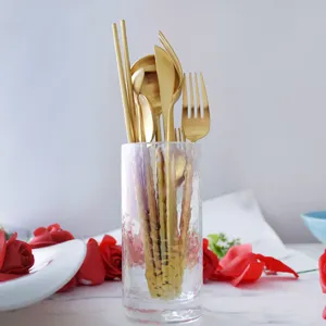 Elegant matte golden stainless steel cutlery set with round handles displayed in glass