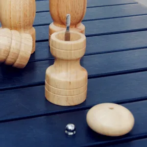 Natural wood manual pepper and salt grinder set with various sizes on a dark table