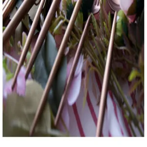 Close-up detail of matte rose gold Portuguese style cutlery handles on floral cloth