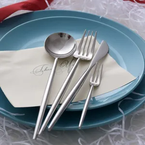 Modern mirror silver stainless steel cutlery set with round handle design on blue plate