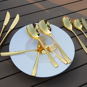 Luxury gold hammered 304 stainless steel cutlery set on white plate.