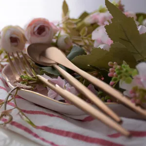 Matte rose gold stainless steel cutlery set with elegant round handles and floral decor