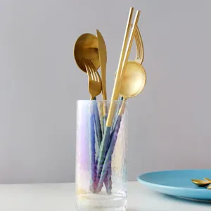 Elegant gold and blue 304 stainless steel cutlery set displayed in a glass holder