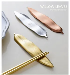 Close-up of willow leaf-shaped metal chopstick rests in gold, silver, and rose gold.