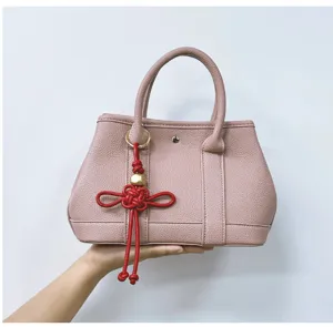 Vue détaillée d'une breloque nœud chinois tressée main en similicuir rouge pour sac