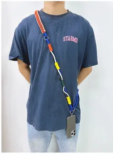 Detailed view of multi-colored handmade woven crossbody phone lanyard on model