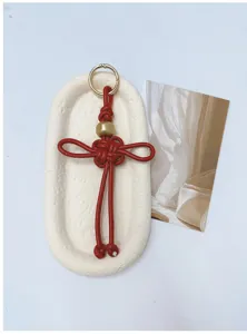 Porte-clés nœud Ruyi rouge tissé à la main en cuir PU avec anneau doré élégant.