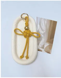 Vue détaillée du pendentif nœud chinois jaune fait main en cuir PU pour sacs et clés