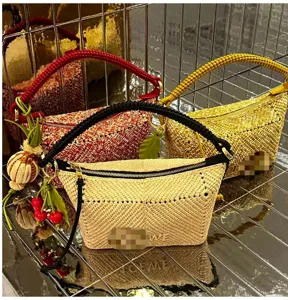 Detail of handmade woven shoulder bags with braided handles and fruit-shaped charms
