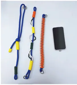 Detailed view of three colorful braided phone and camera lanyards with size reference