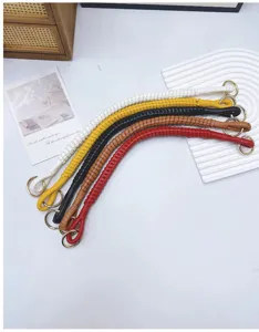 Detailed view of multiple handwoven PU leather bag straps featuring elegant gold rings.