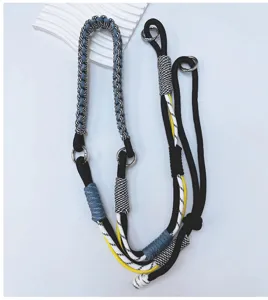 Detail of hand-woven adjustable phone lanyard with metal rings and multicolored cords.