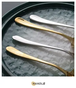 Close-up of mirror finish stainless steel spoon handles in gold and silver colors.