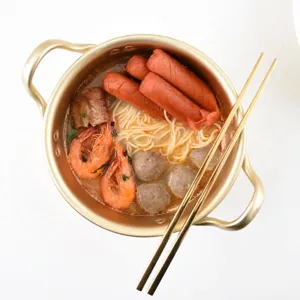 Traditional golden Korean ramen pot for noodles shown with food and matching chopsticks