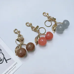 Simulation cherry keychains with glitter resin fruits and gold-colored metal leaf charms.