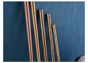 Detail view of assorted long wooden chopsticks showing natural textures and grains